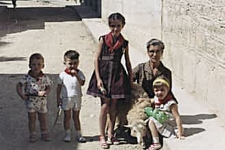 Fiestas de 1962. José Mª y Pedro Mª Mañeru, Begoña Astarriaga con la abuela Dolores Belda y Loli Mañeru. Sostienen a una oveja para la fotografía.