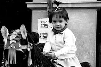 1968. Ana Mañeru Sesma, montada en un caballito en la plaza de los Fueros.