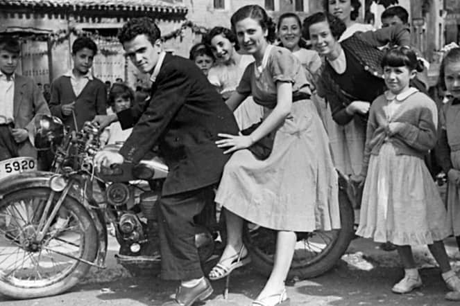 Década de los 50. En la imagen Carmen Montoya y su hermano Rodolfo Montoya subido en una moto y rodeados de jóvenes.