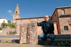 Pablo Nogales posa junto a una de sus creaciones en la misma carretera de Mues. A sus espaldas